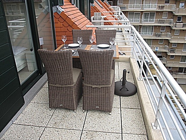 Groot terras vooraan met teakhouten tuinmeubelen